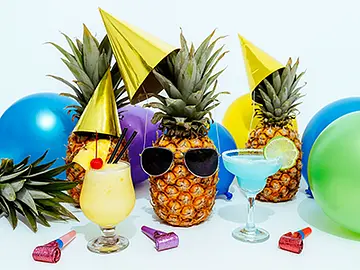 A colourful hens party drinks setup featuring tropical cocktails, pineapples wearing party hats and sunglasses, and bright balloons. The playful arrangement captures a fun and vibrant party atmosphere, perfect for hens parties, birthdays, and private events.
